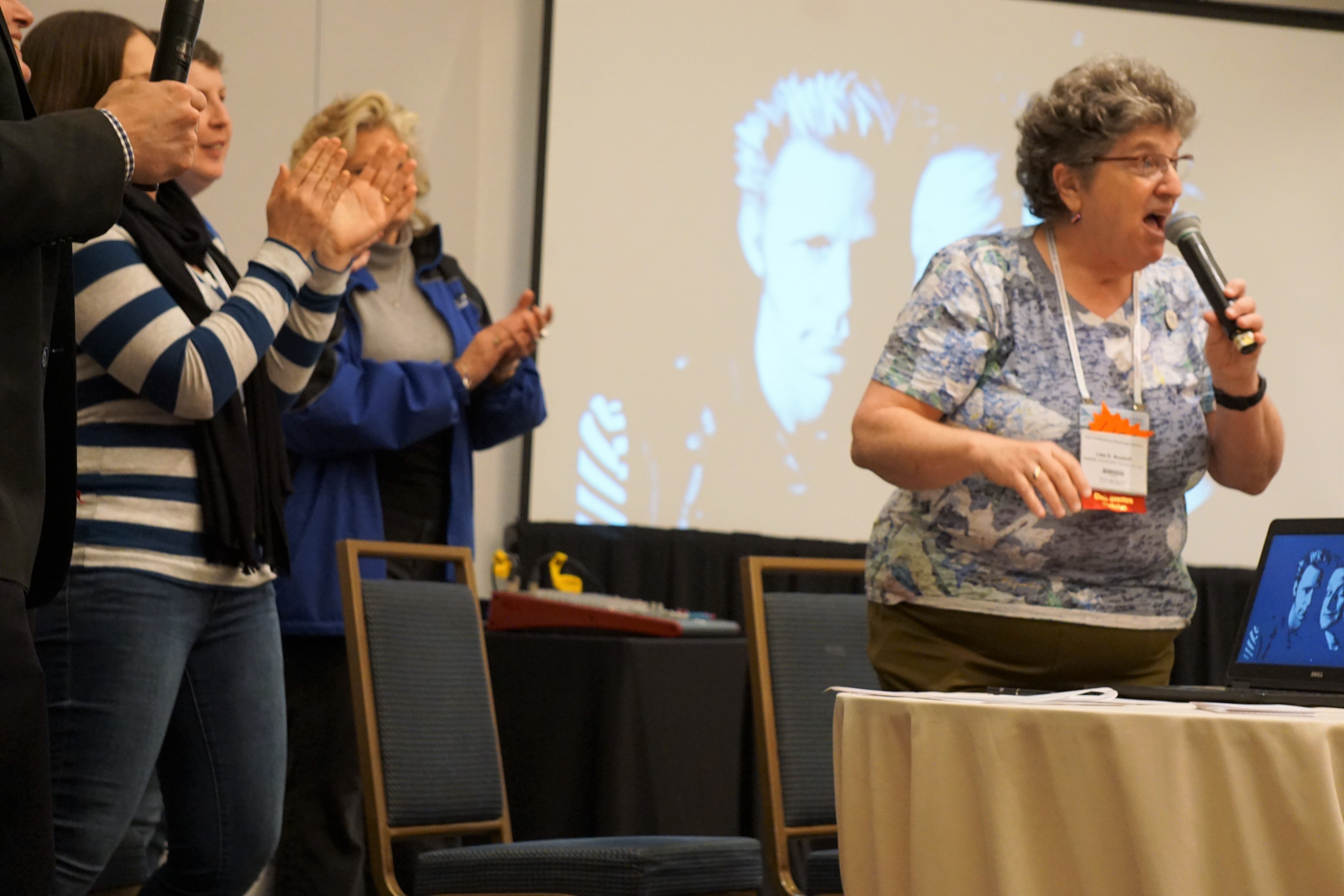 Conference planning committee Chair Lisa Brodoff (Seattle Law) leads attendees in a karaoke sing along.
