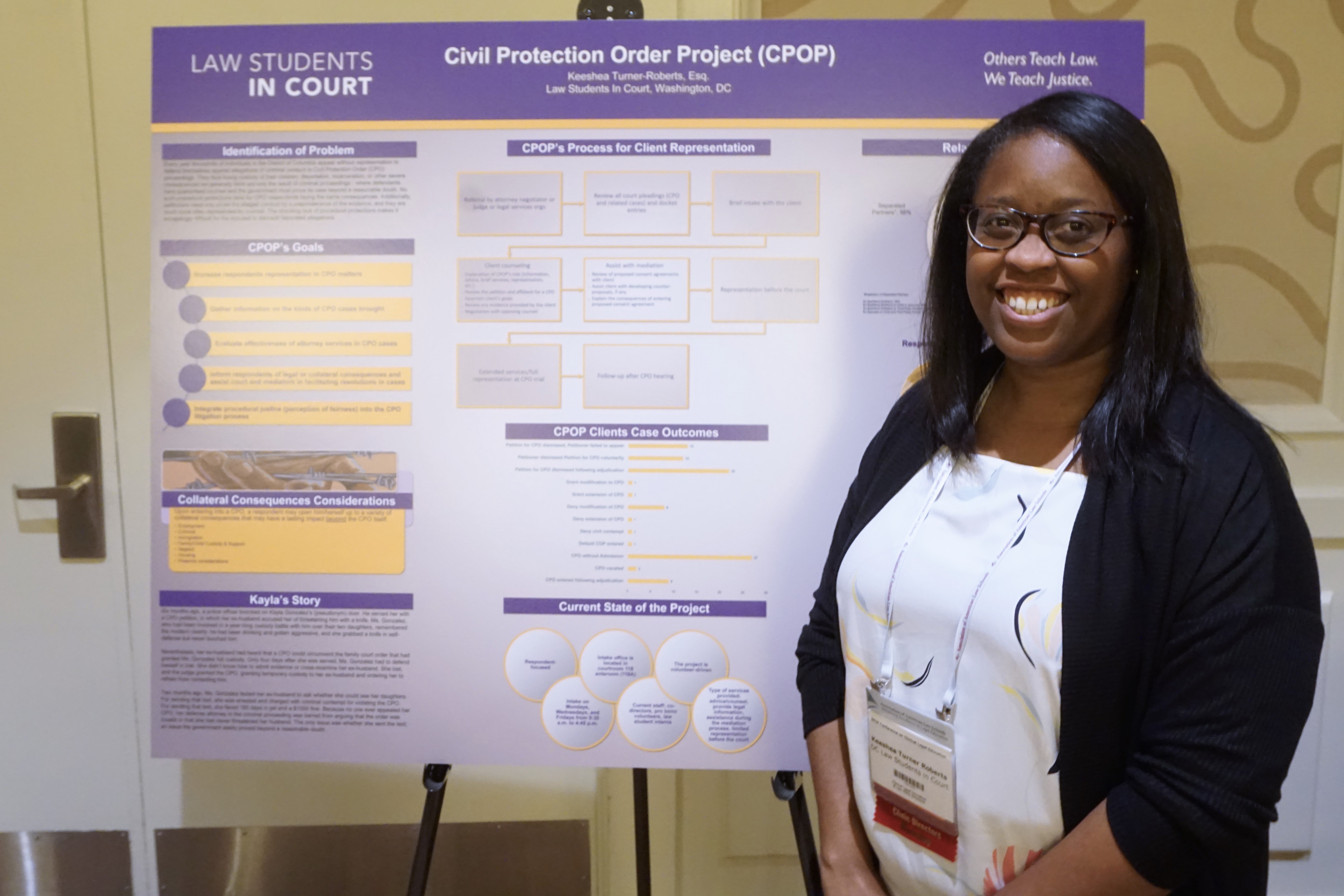 Keeshea Turner Roberts (DC Law Students in Court) displays her group's poster "Ensuring Fairness in the Process: Civil Protection Order Project."